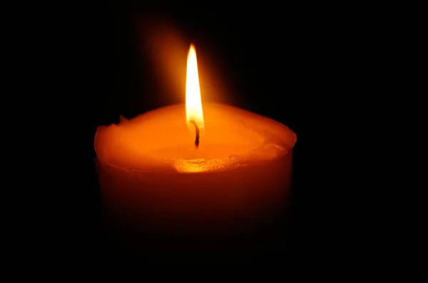 孤独的橙色蜡烛在黑暗中闪耀 — 图库照片
