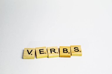 Scrabble tiles with word verbs written in a white background clipart