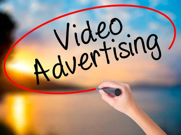 Women Hand writing Video Advertising with black marker on visual screen. Isolated on Sunset. Business, technology, internet concept. Stock Photo