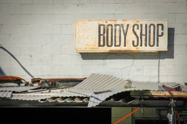 Recession Image Of Grungy Sign For A Rundown Body Shop clipart