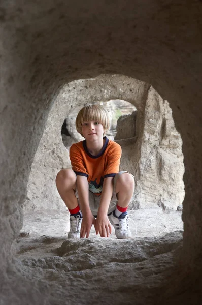 Sonriente Niño Sentado Detrás Del Túnel Piedra — Foto de Stock
