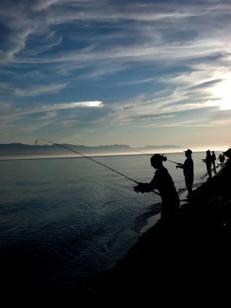 Silhouetten Von Menschen Die Mit Einem Sonnenhund Ufer Lachse Angeln — Stockfoto
