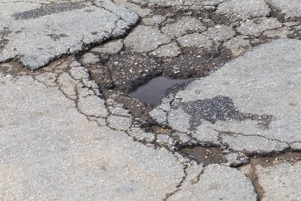 悪い古い道路 街路のアスファルトに大きな穴 — ストック写真