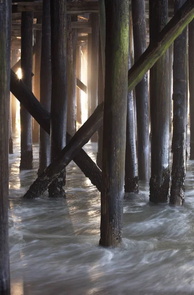 潮が流れ 朝の光が見える場所が見える桟橋の下の木製の杭は ニュージャージー海岸 シーサイドハイツ カジノピアです モーションブラー 遅いシャッタースピード使用 — ストック写真