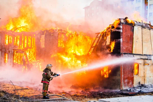 Strażak Gaśnie Ogień Stary Dom Drewniany — Zdjęcie stockowe