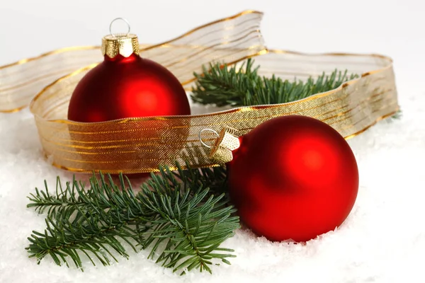 2つの赤いクリスマスボール 雪のモミの枝 白い背景に隔離 — ストック写真