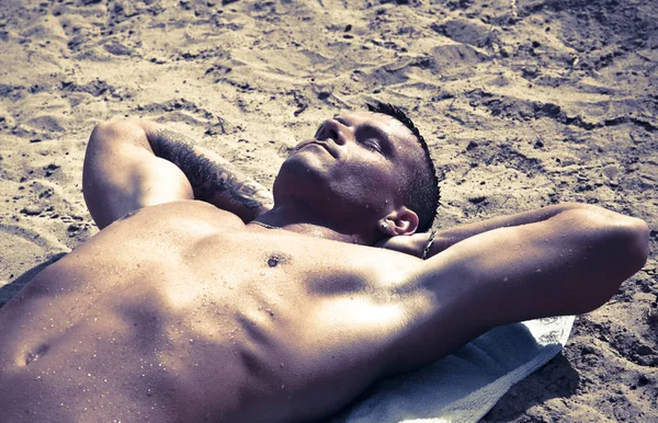 年轻英俊的男子在游泳后躺在沙滩上休息 — 图库照片