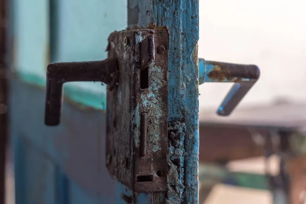 ブルーに塗られた風化ドアが木製の古い金属ドアノブのクローズ アップ — ストック写真