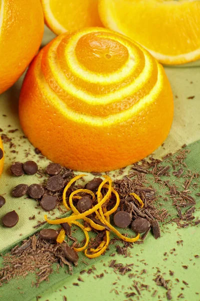 Peeled navel orange with chocolate drops and shards with orange rind.
