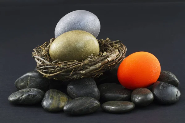 三个巢蛋与银和金在巢中表现良好 红巢蛋在岩石上和巢外 标志着投资组合中需要关注的一个部门 — 图库照片