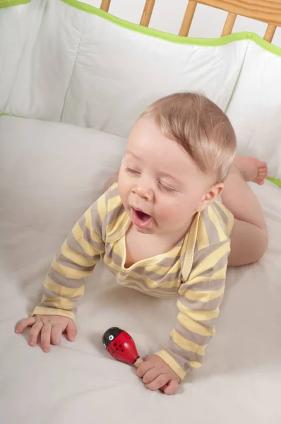 Baby Gähnt Seinem Bett Mit Spielzeug Der Hand — Stockfoto