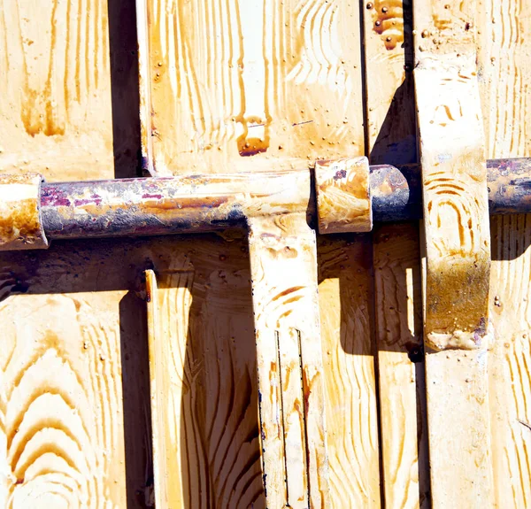 棕色摩洛哥非洲旧的木立面回家和生锈的安全挂锁 — 图库照片