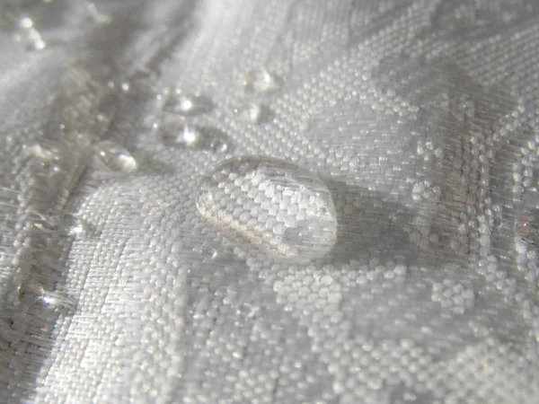 sunlit drops of water on white cloth