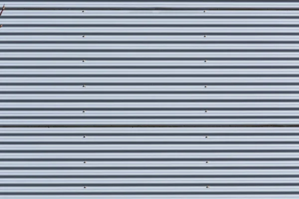 Silver-colored metal wall corrugated sheet metal background.