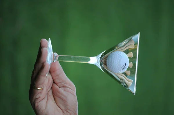 golf ball and tees in martini glass