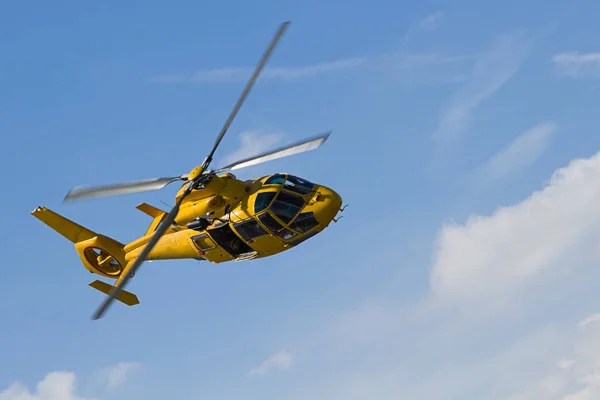 黄色直升机带着云彩在蓝天中飞行 — 图库照片