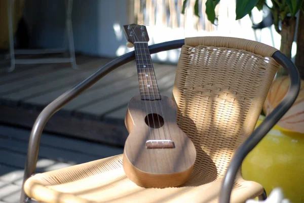 Mała Drewniana Gitara Spoczywającej Wikliny Metalowym Krześle — Zdjęcie stockowe
