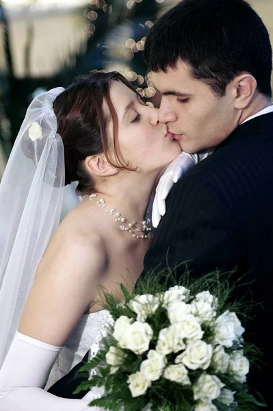 Jovem Casal Recém Casado Beijando Pasionalmente Noiva Segurando Buquê Flores — Fotografia de Stock