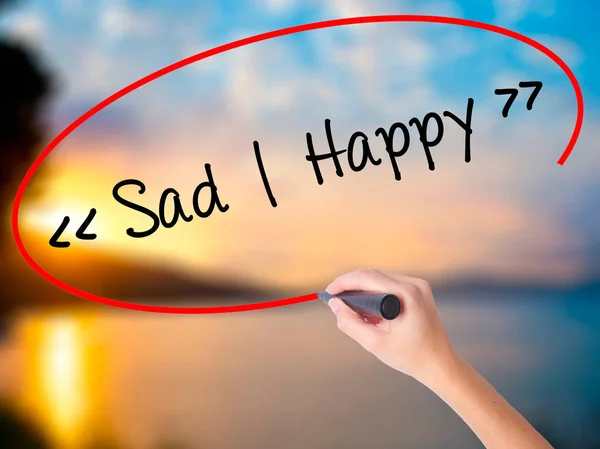 Women Hand writing Sad - Happy with black marker on visual screen. Isolated on Sunset. Business, technology, internet concept. Stock Photo