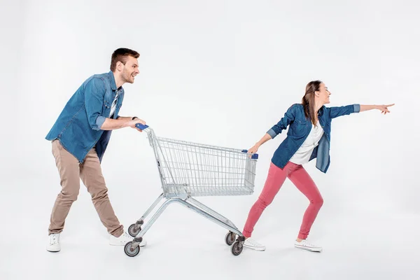 Mujer Señalando Camino Mientras Tirando Del Carro Compra Con Hombre — Foto de Stock