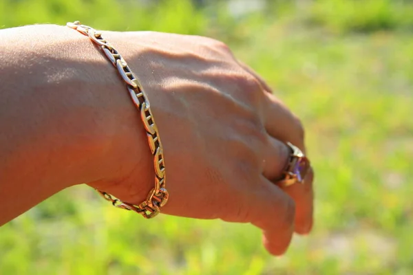 Kvinnans Hand Med Guld Ringar Och Guld Armband Över Grönt — Stockfoto