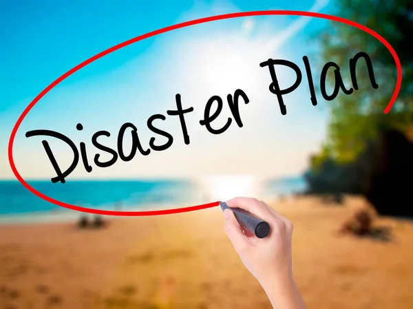 Women Hand writing Disaster Plan with black marker on visual screen. Isolated on beach. Business, technology, internet concept. Stock Photo