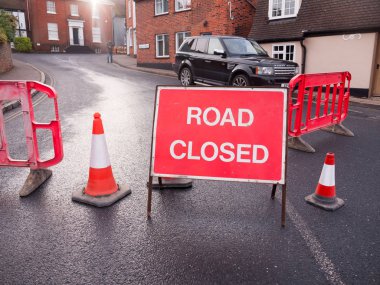 big red road closed sign fences and cones blocked path change direction  essex  england  uk clipart
