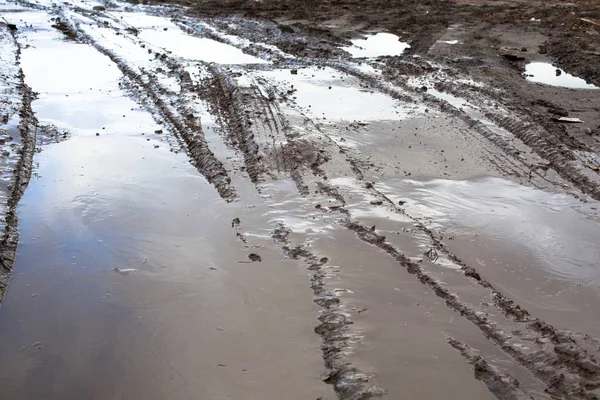 未舗装の道路上の泥や水たまり — ストック写真
