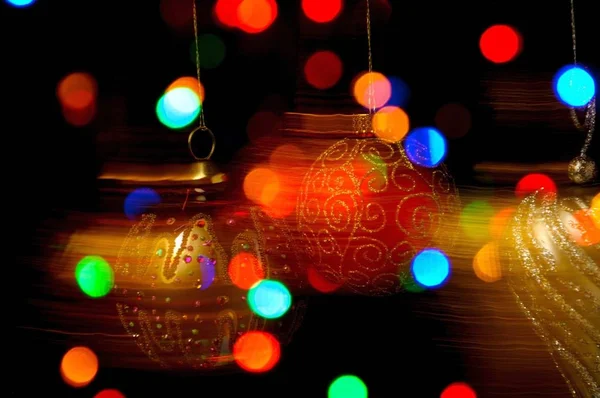 Bauble Natal Ornamentado Pendurado Contra Fundo Preto Com Luzes Coloridas — Fotografia de Stock