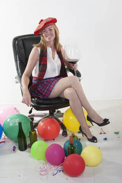 Party goer wearing a kilt and drinking wine