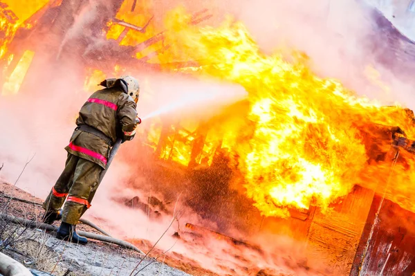 Tűzoltó Kialszik Tűz Egy Régi Fából Készült Ház — Stock Fotó