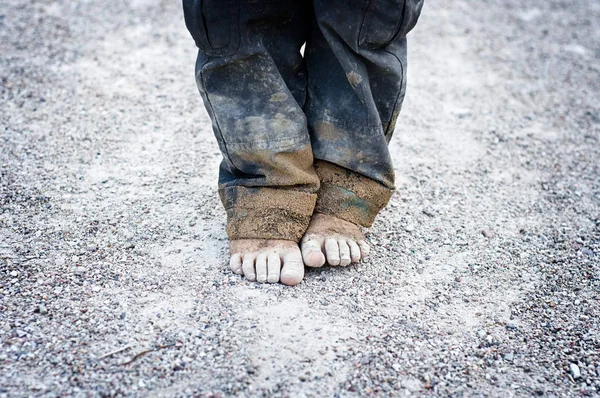 砂利の上に汚いと裸の子供の足 貧困概念 — ストック写真
