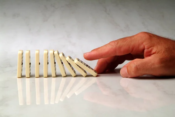 Row Dominoes Pushed Hand Neutral Background — Stock Photo, Image