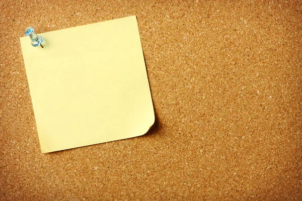 コルクボードの背景にピン留めされた空白の付箋 — ストック写真