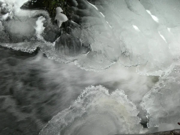 小川は氷で覆われ 水は小さなストリームでそれらの下に流れます — ストック写真