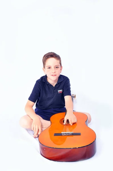 Plano Estudio Chico Joven Con Una Guitarra Acústica Aislado Sobre —  Fotos de Stock