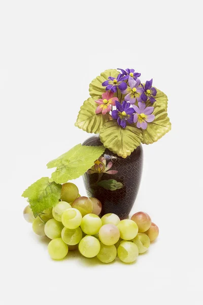 瓷花瓶 人造花和白色背景上的绿色葡萄 — 图库照片