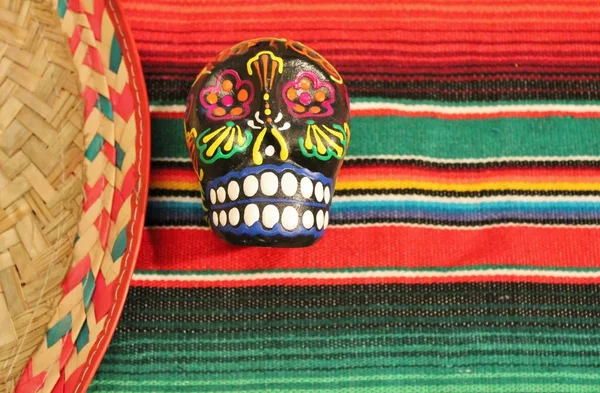 Mexico fiesta poncho candy skull sombrero in bright stripe background with copy space