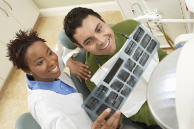 Dentist Showing Tooth X-Ray To Patient clipart