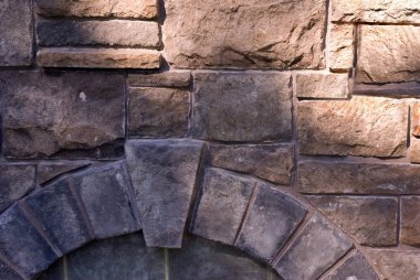 Close up detail of stone wall with arch and keystone. clipart