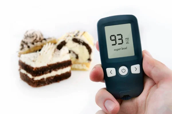 手控股米 糖尿病做血糖水平测试 在背景中的蛋糕 — 图库照片