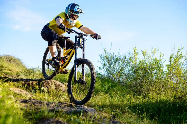黄色のTシャツとヘルメットで自転車ダウンロッキーヒルに乗ってプロのサイクリスト エクストリームスポーツコンセプト — ストック写真