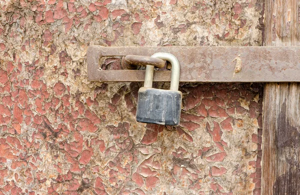 破損した木製ドア表面に古い錆びた南京錠 — ストック写真