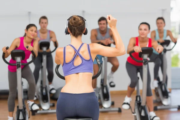 Female trainer and fitness class at spinning class in gym