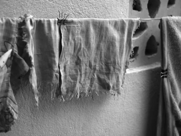 BLACK AND WHITE PHOTO OF OLD AND FADED HANDKERCHIEF DRYING OUTSIDE