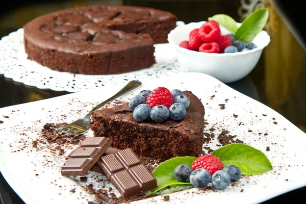 Choklad Tårta Med Färska Bär Vita Skålen Och Svart Bakgrund — Stockfoto