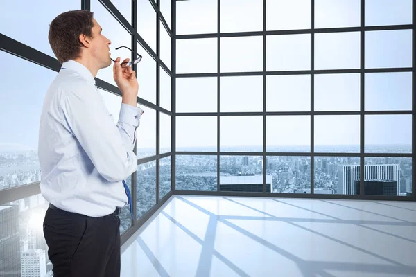 Pensando Hombre Negocios Mordiendo Gafas Contra Habitación Con Grandes Ventanas — Foto de Stock