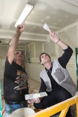 Two plasterers working together clipart