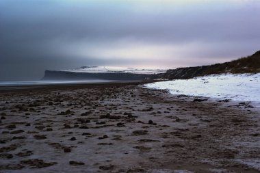 Huntcliff at Saltburn, North Yorkshire, viewed from the snow covered beach at Marske By The Sea clipart