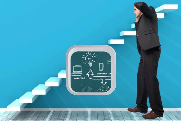 Stressed businessman with hands on head against steps in a blue room